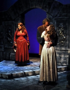 King Henry (Don Matthews) kisses mistress French Princess Alais (Holly Nienhaus) watched by disaffected wife Queen Eleanor (Livia Genise). (photo by Roy Von Rains, Jr.)