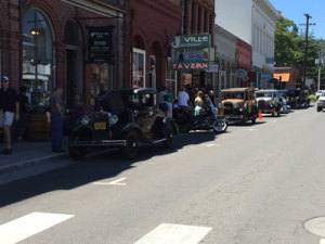 2015 Taste of Summer Celebration attendees examine some of the vintage automobiles lining California Street in Jacksonville, OR on June 6, 2015.
