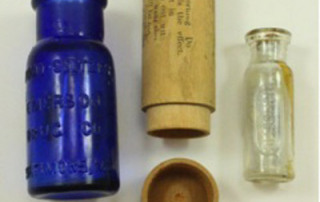 From Left: Cobalt blue Bromo-Seltzer bottle, and a Dr. B. Hunt’s Corn Treatment bottle and wooden case.