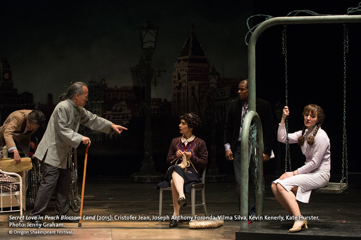 Jiang (Cristofer Jean), at left, and Yun (Kate Hurster), on swing, acting in a scene from Secret Love while the Director (Joseph Anthony Foronda) makes a point with Mrs. Jiang (Vilma Silva) and Assistant Director Kevin Kenerly looks on in OSF’s Secret Love In Peach Blossom Land. Photo by Jenny Graham.