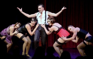 Emcee (Galloway Stevens) surrounded by Kit Kat Girls (l-r) Lulu (Sierra Wells), Helga (Layli Kayhani), Kost (Leah Kolb) and Bobby (Kerry Lambert) in Oregon Cabaret Theater's production of "Cabaret".